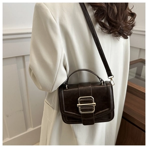 Détail du sac carré rétro marron foncé avec boucle dorée et texture cuir élégante