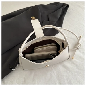 Internal view of a white PU leather handbag showing storage space for phone and wallet