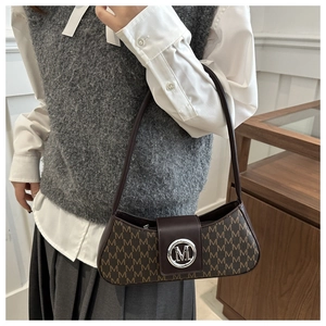 Détail d'un sac en cuir marron avec imprimé lettres M et boucle en métal argenté