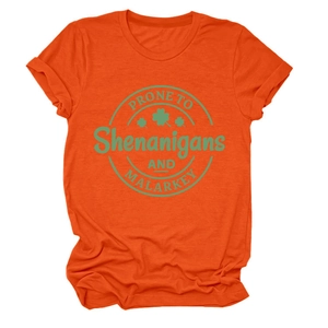 Detailed view of the green St. Patrick's Day graphic print on an orange crewneck T-shirt