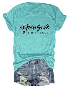 Flat lay of a teal crew neck t-shirt with 'expensive & DIFFICULT' text and denim shorts