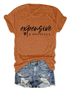 Flat lay of orange cotton T-shirt with black artistic typography and denim shorts