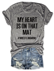 Flat lay of gray wrestling mom t-shirt with blue distressed denim shorts on white background
