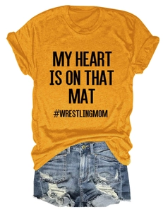 Flat lay of yellow t-shirt with #WRESTLINGMOM text and distressed denim shorts