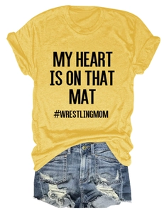 Detail of yellow cotton T-shirt fabric with My Heart Is On That Mat wrestling print
