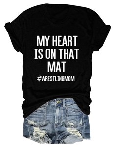 Flat lay of black My Heart Is On That Mat wrestling mom t-shirt with ripped denim shorts
