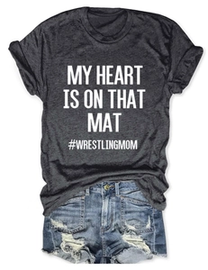 Flat lay of gray Wrestling Mom t-shirt with distressed denim shorts and fringed hem detail