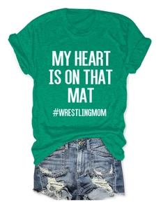 Detailed flat lay of green crew neck T-shirt with white text and ripped denim shorts
