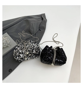 Detail of sequined bucket bag with delicate chain strap and elegant pearl drawstring accents