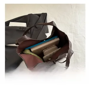 Macro view of spacious dark brown woven tote interior showing storage for daily essentials