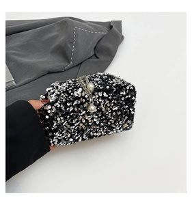 Macro shot of silver sequins on drawstring bucket bag with pearl chain detail