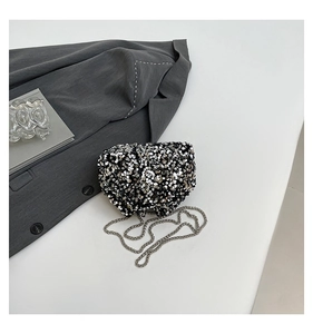 Detailed view of silver and black sequins with elegant metal chain on bucket bag