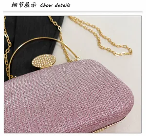 Dettaglio della borsa da sera con paillettes rosa, fibbia di strass e manico in metallo