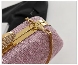 Dettaglio borsa da sera rosa glitterata con chiusura a cuore di cristallo dorata