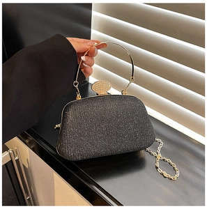 Dettaglio borsa da sera nera con paillettes, manico dorato e chiusura decorata con strass