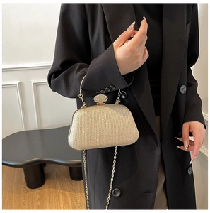 Dettaglio borsa da sera oro champagne con strass e manico in metallo elegante