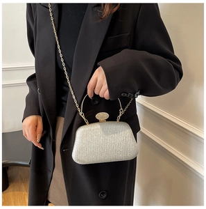 Dettaglio pochette da sera in strass argento con catena dorata sottile e manico metallico