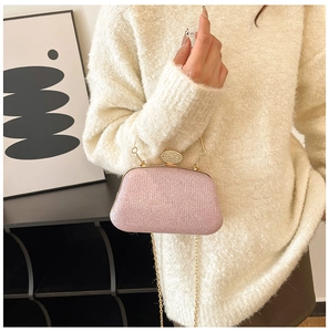 Dettaglio borsa da sera rosa glitterata con chiusura strass dorata e tracolla a catena