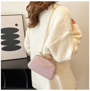 Borsa da sera rosa glitterata con fibbia di cristallo e catena dorata indossata da modella