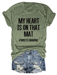 Flat lay of army green wrestling mom t-shirt with distressed blue denim shorts