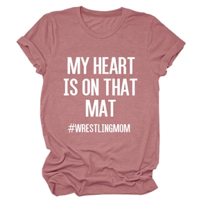 Detail of dusty rose wrestling mom t-shirt with white text on textured cotton fabric