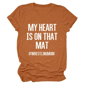 Close-up of rust red cotton t-shirt with white MY HEART IS ON THAT MAT printed text