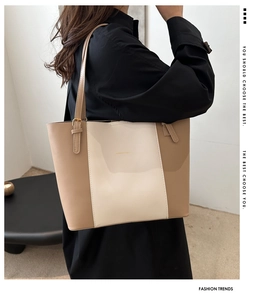 Detail of a large color-block tote bag in beige and khaki with adjustable straps