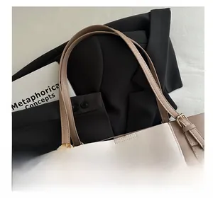Close-up of contrast stitching and gold buckle details on the khaki tote bag