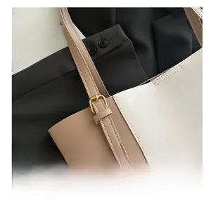 Close-up of contrast color tote bag with fine stitching and golden metal buckle details