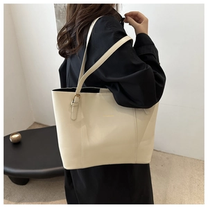 Detail of cream leather tote bag featuring gold FASHION & BAG lettering and stitching