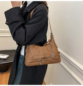 Detail of vintage brown leather dumpling bag with silver buckle and adjustable shoulder strap