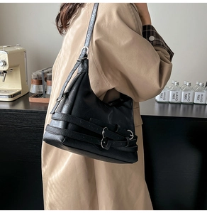 Dettaglio della borsa hobo in pelle nera opaca con fibbie d'argento e cinturini in pelle