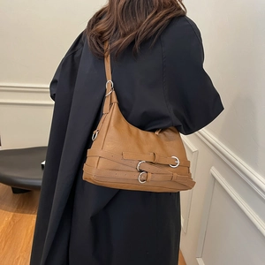 Vintage brown leather tote bag with silver multi-buckle straps shown on a model