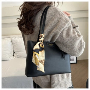 Detailed view of a black large-capacity tote bag featuring a decorative silk scarf handle