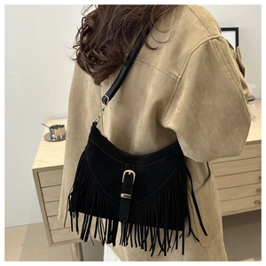 Dettaglio della borsa tote in pelle scamosciata nera con frange e fibbia dorata