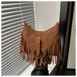 Detailed view of brown suede fringe shoulder bag with bohemian tassels and metallic buckle
