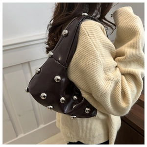 Detail of dark brown leather armpit bag with silver metallic studs and soft texture