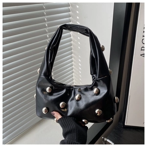 Détail du sac sous l'aisselle en cuir noir avec de grands ornements de boules cloutées