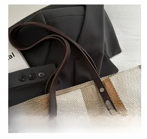 Detailed close-up of woven vertical stripes texture and leather handle with metal rivets