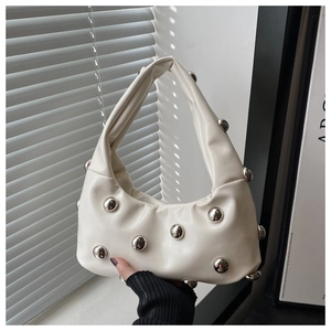 Détail du sac à main crème en PU avec rivets argentés et base plissée élégante