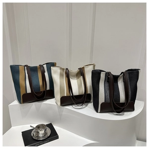Detailed view of large canvas tote bags with stripe patterns and faux leather handles