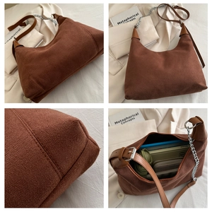 Detail view of large brown suede bucket bag showing texture, chain strap and interior space
