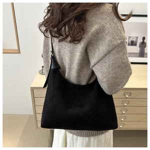 Detail of adjustable strap and silver metal buckle on black crescent shoulder bag