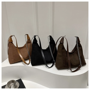 Close-up of retro suede tote bags in brown and black with silver chain straps