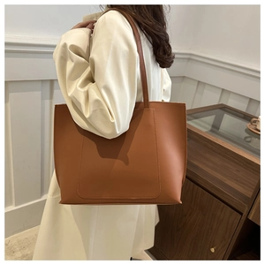 Detailed side view of the caramel tote bag showing matte texture and stitching accents