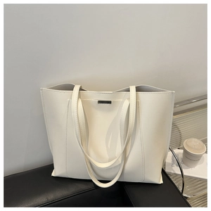 Detail view of cream white PU leather tote bag with elegant metallic buckle ornament