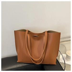Detail of the silver metal trim on a large brown PU leather tote bag for daily commute
