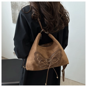 Detailed view of a vintage brown frosted shoulder bag with bow knot and lace-up design