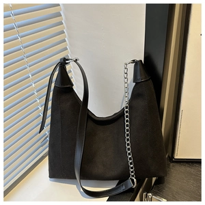 Detail view of black canvas hobo bag with adjustable leather strap and silver chain
