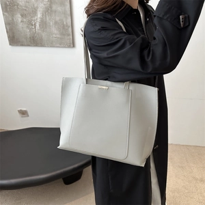 Chic minimalist grey tote bag in matte leather featuring a functional front pocket